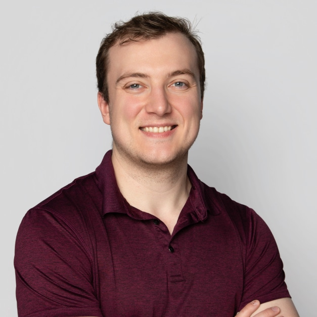 Person smiling, wearing a burgundy polo shirt with arms crossed.