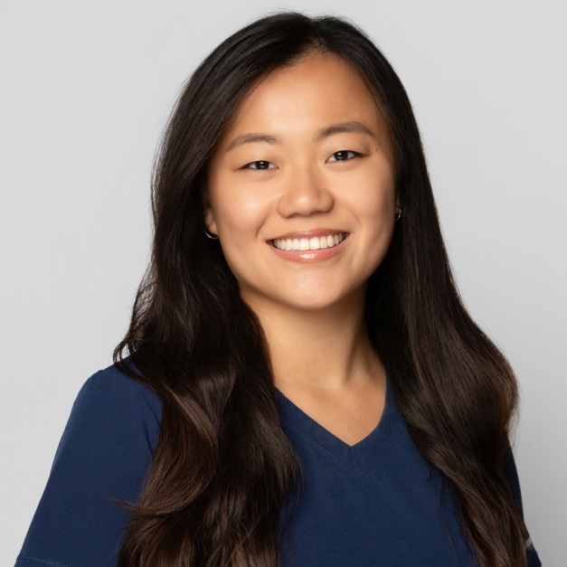 Smiling woman with long dark hair wearing a navy blue top.